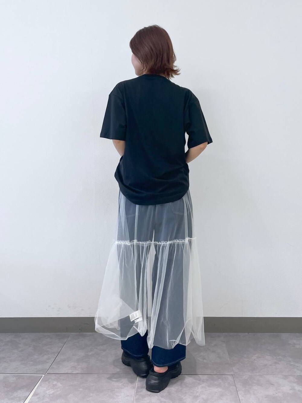 ブラック系のTシャツ/カットソー、ブルー系のデニムパンツ、ブラック系のサンダルを着用したレディースの夏コーディネートの3枚目の写真