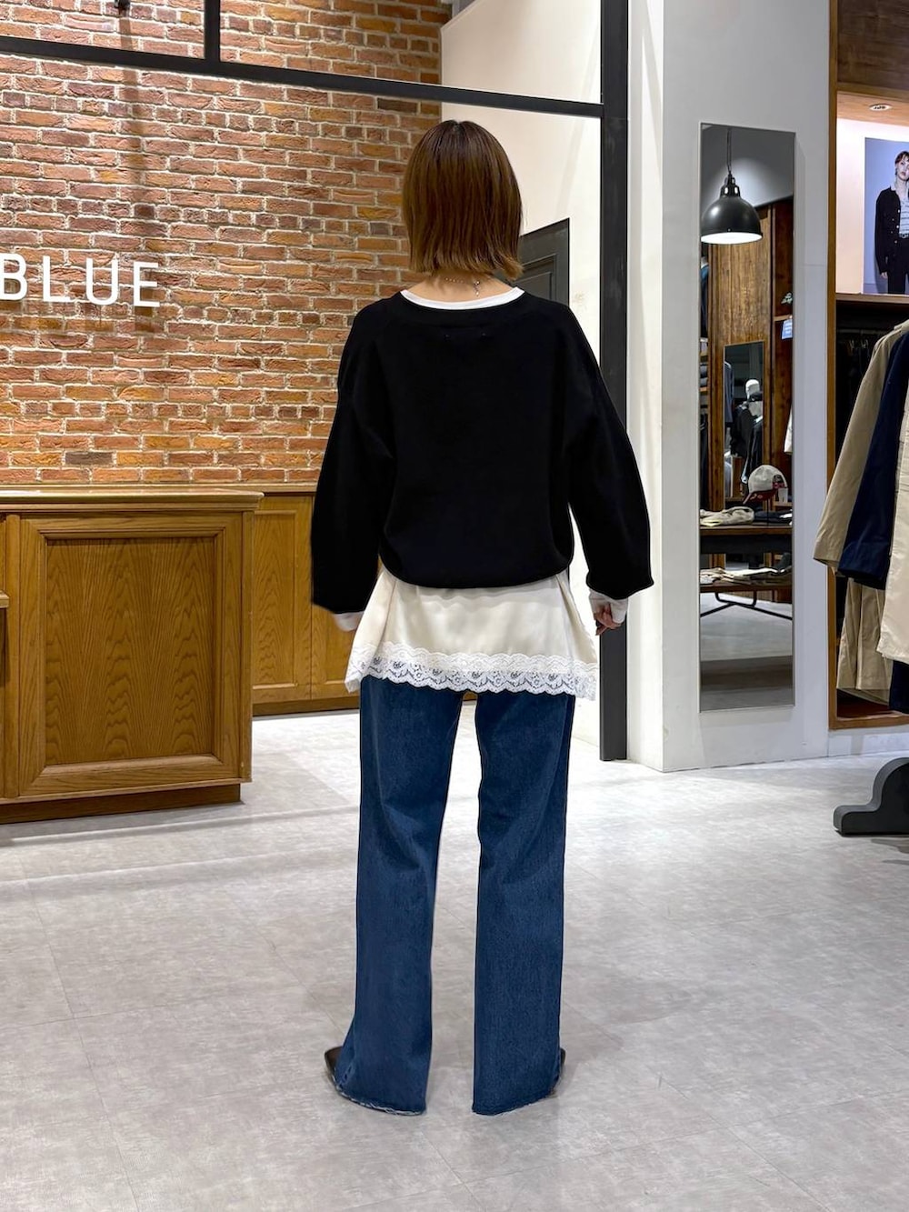 ブラック系のパンプス、ブルー系のデニムパンツ、ホワイト系のキャミソールを着用したレディースの春コーディネートの4枚目の写真