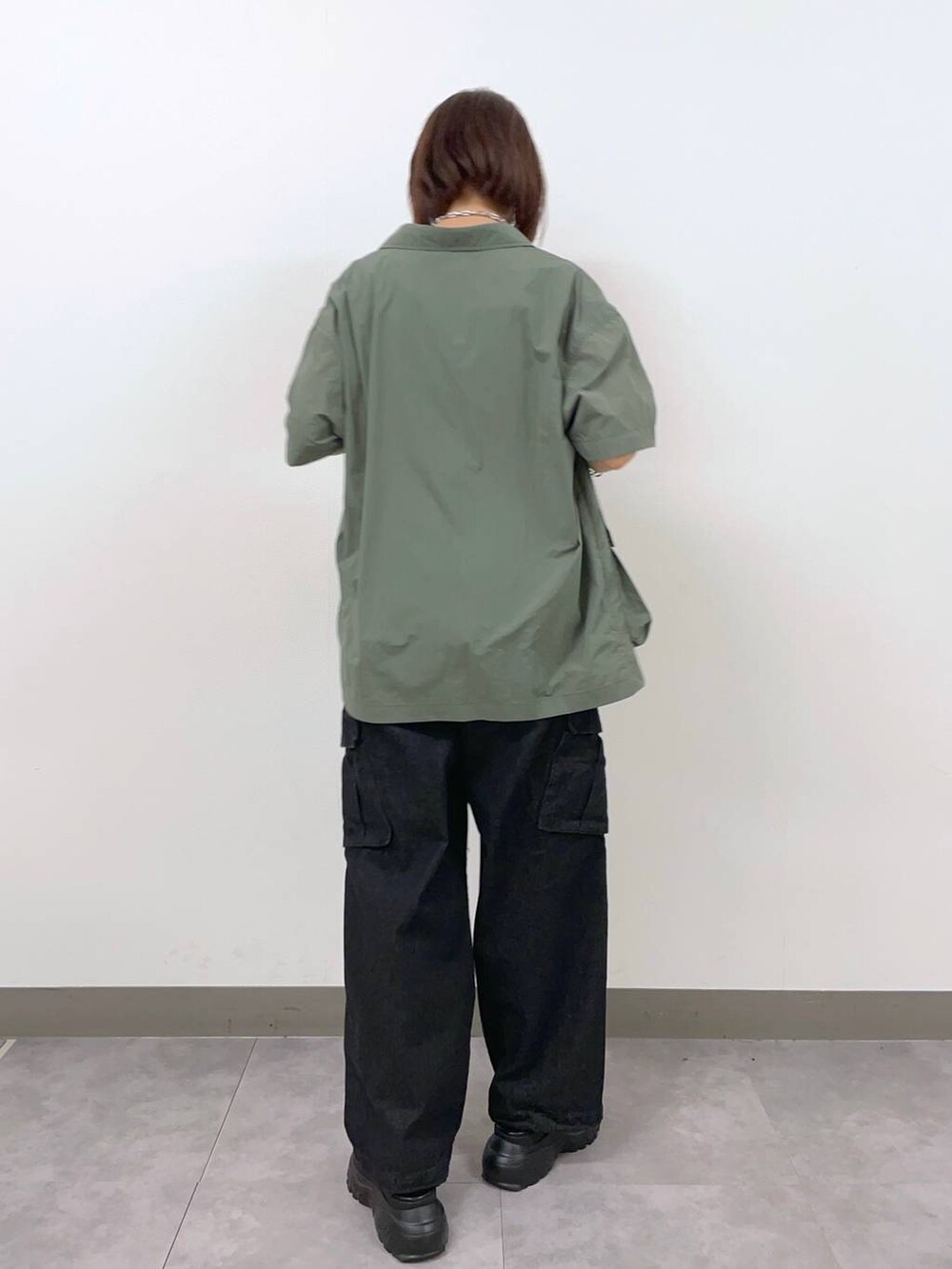 グレー系のデニムパンツ、グリーン系のシャツ/ブラウス、ブラック系のサンダルを着用したレディースの夏コーディネートの3枚目の写真