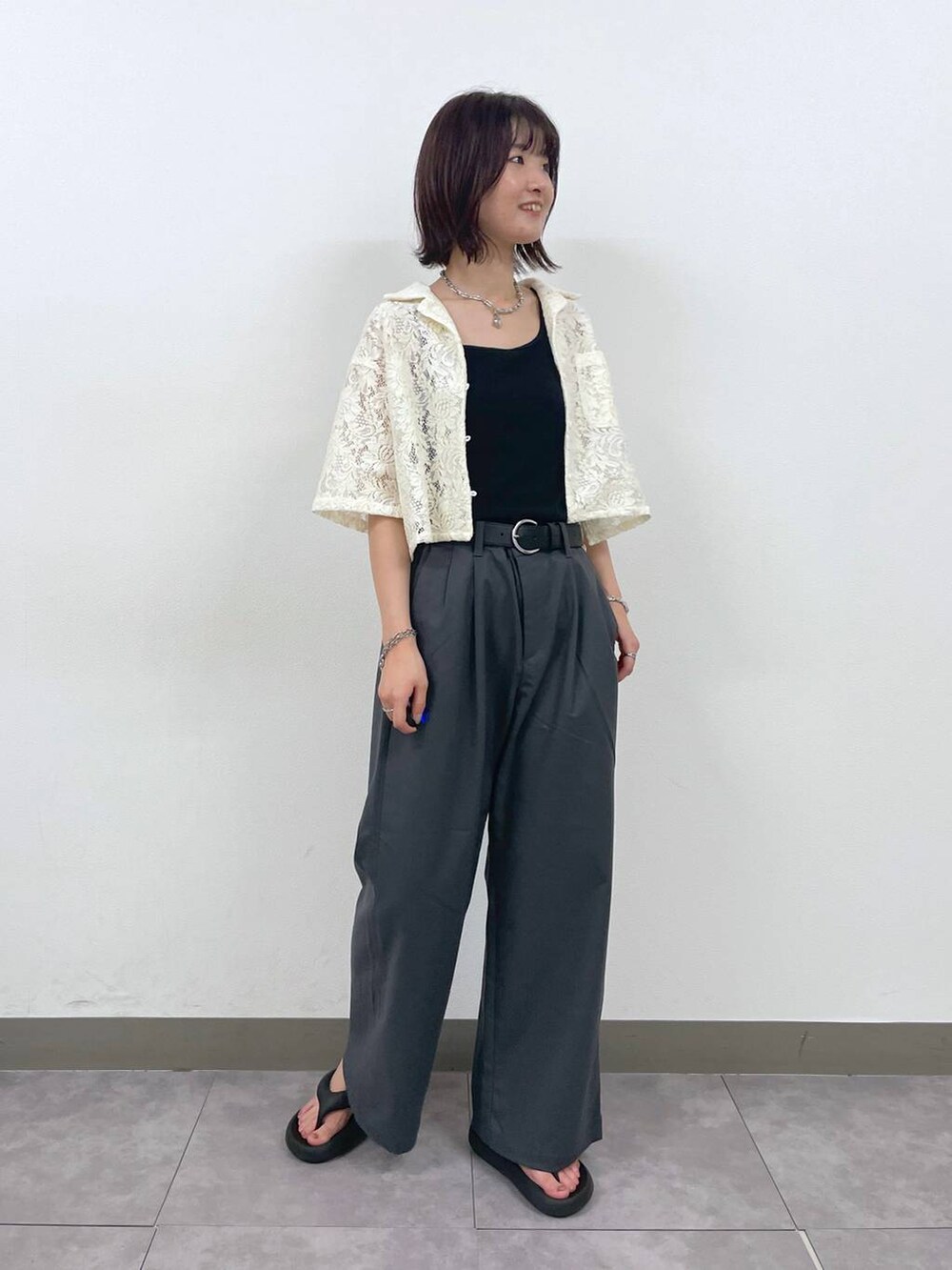 グレー系のスラックス、ホワイト系のシャツ/ブラウス、シルバー系のブレスレットを着用したレディースの夏コーディネートの4枚目の写真