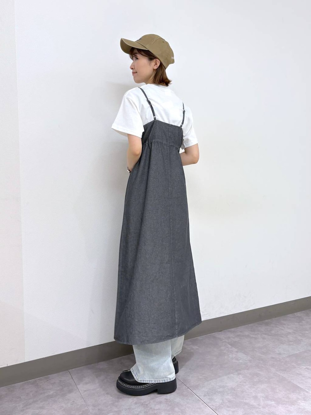 ブラック系のローファー、ブルー系のデニムパンツ、グレー系のワンピースを着用したレディースの春コーディネートの4枚目の写真