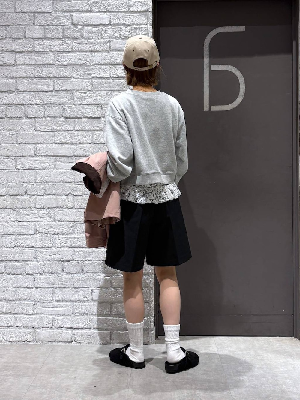 ブラック系のスラックス、ピンク系のブルゾン、グレー系のスウェットを着用したレディースの冬コーディネートの4枚目の写真