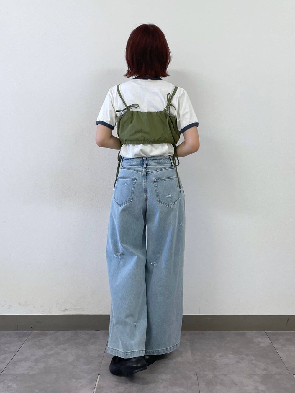 ブラック系のスニーカー、ブルー系のTシャツ/カットソー、ブルー系のデニムパンツを着用したレディースの夏コーディネートの5枚目の写真