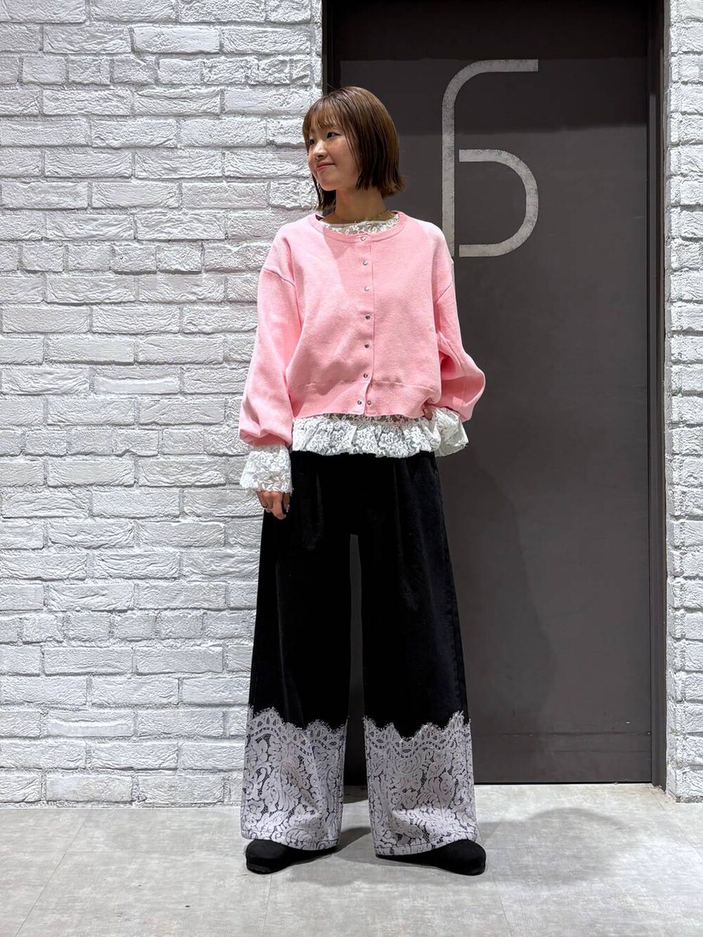 ピンク系のカーディガン/ボレロ、ブラック系のデニムパンツ、ブラック系のモカシン/デッキシューズを着用したレディースの冬コーディネートの5枚目の写真