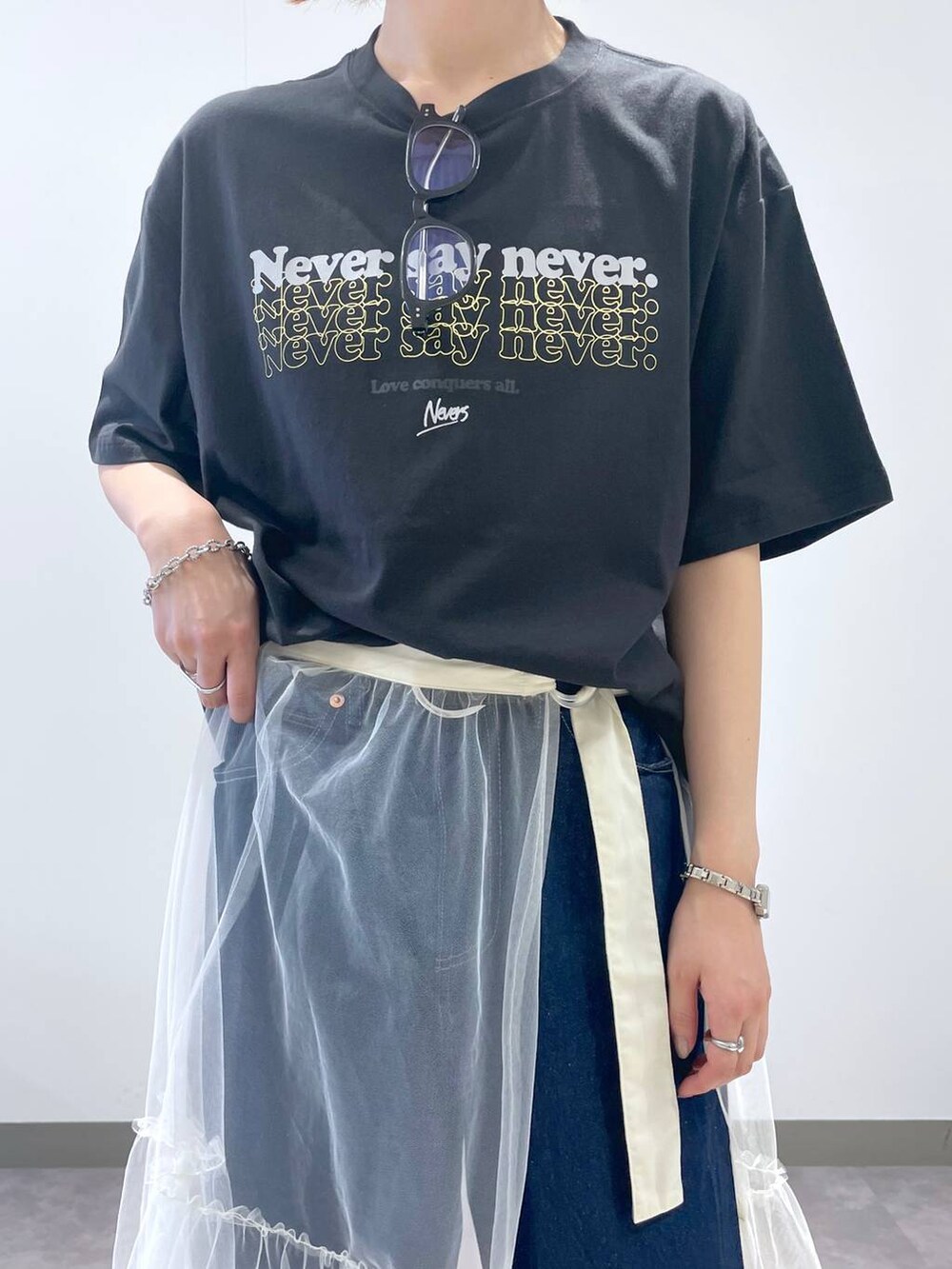 ブラック系のTシャツ/カットソー、ブルー系のデニムパンツ、ブラック系のサンダルを着用したレディースの夏コーディネートの5枚目の写真
