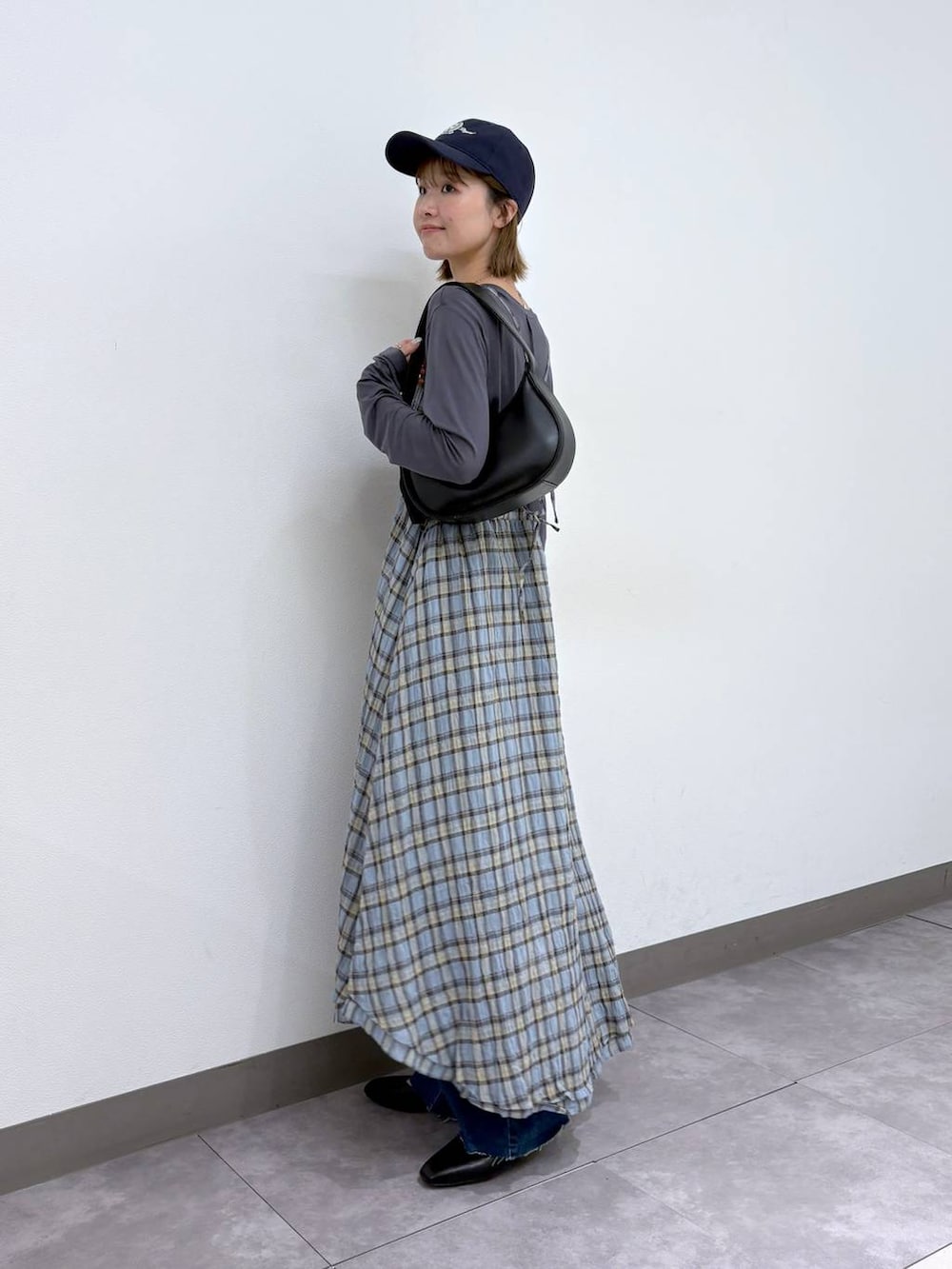 ブラック系のパンプス、ブルー系のデニムパンツ、ブラック系のショルダーバッグを着用したレディースの春コーディネートの3枚目の写真