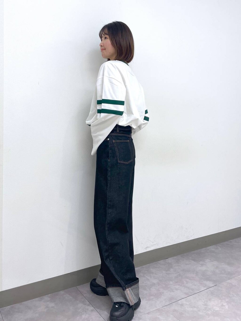 ホワイト系のTシャツ/カットソー、ブラック系のデニムパンツ、ブラック系のスニーカーを着用したレディースの春コーディネートの5枚目の写真