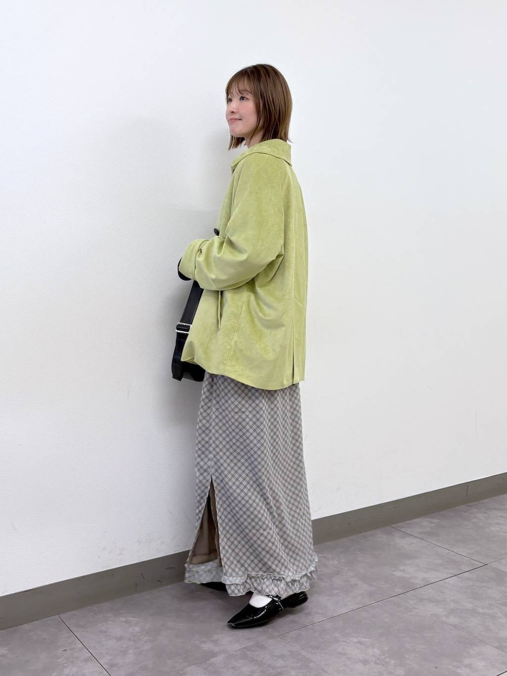 ブラック系のカーディガン/ボレロ、ブラック系のショルダーバッグ、グリーン系のブルゾンを着用したレディースの春コーディネートの3枚目の写真