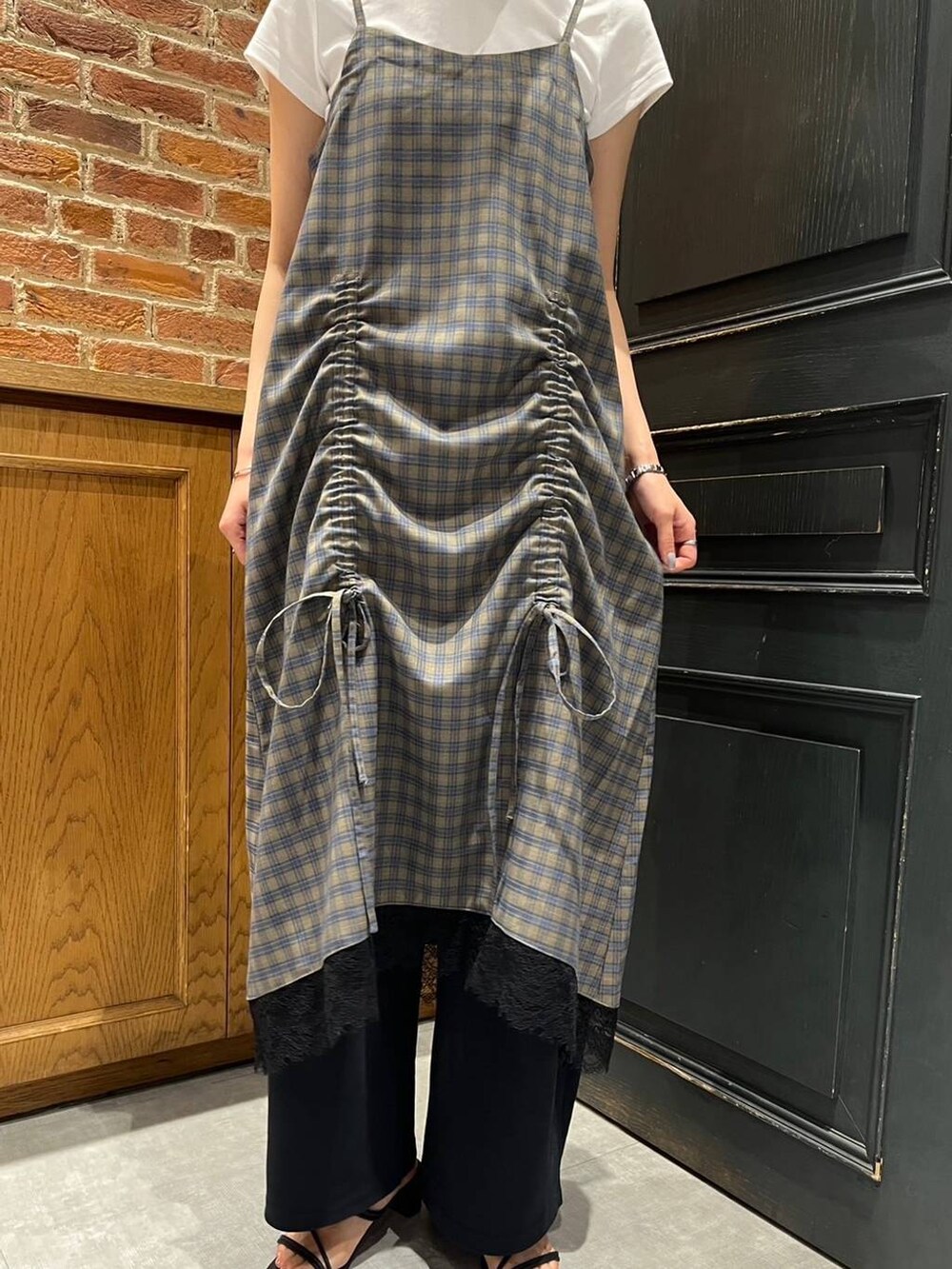 ブラック系のサンダル、ブラック系のスウェットパンツ、イエロー系のワンピースを着用したレディースの夏コーディネートの2枚目の写真