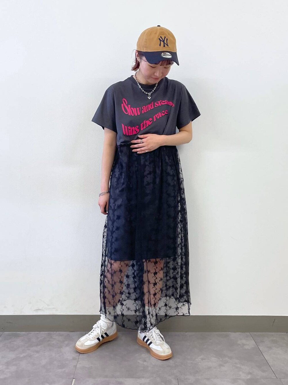 グレー系のワンピース、ブルー系のキャップ、シルバー系のブレスレットを着用したレディースの夏コーディネートの5枚目の写真