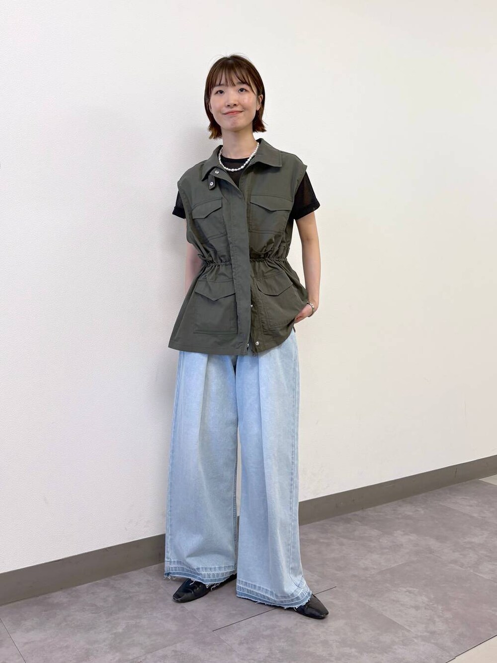 ブラック系のTシャツ/カットソー、ブルー系のデニムパンツ、グリーン系のベストを着用したレディースの夏コーディネートの6枚目の写真