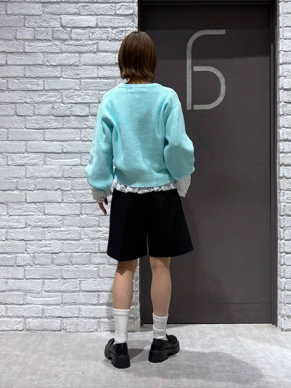 ブラック系のローファー、ブラック系のスラックス、ブルー系のニット/セーターを着用したレディースの冬コーディネートの4枚目の写真