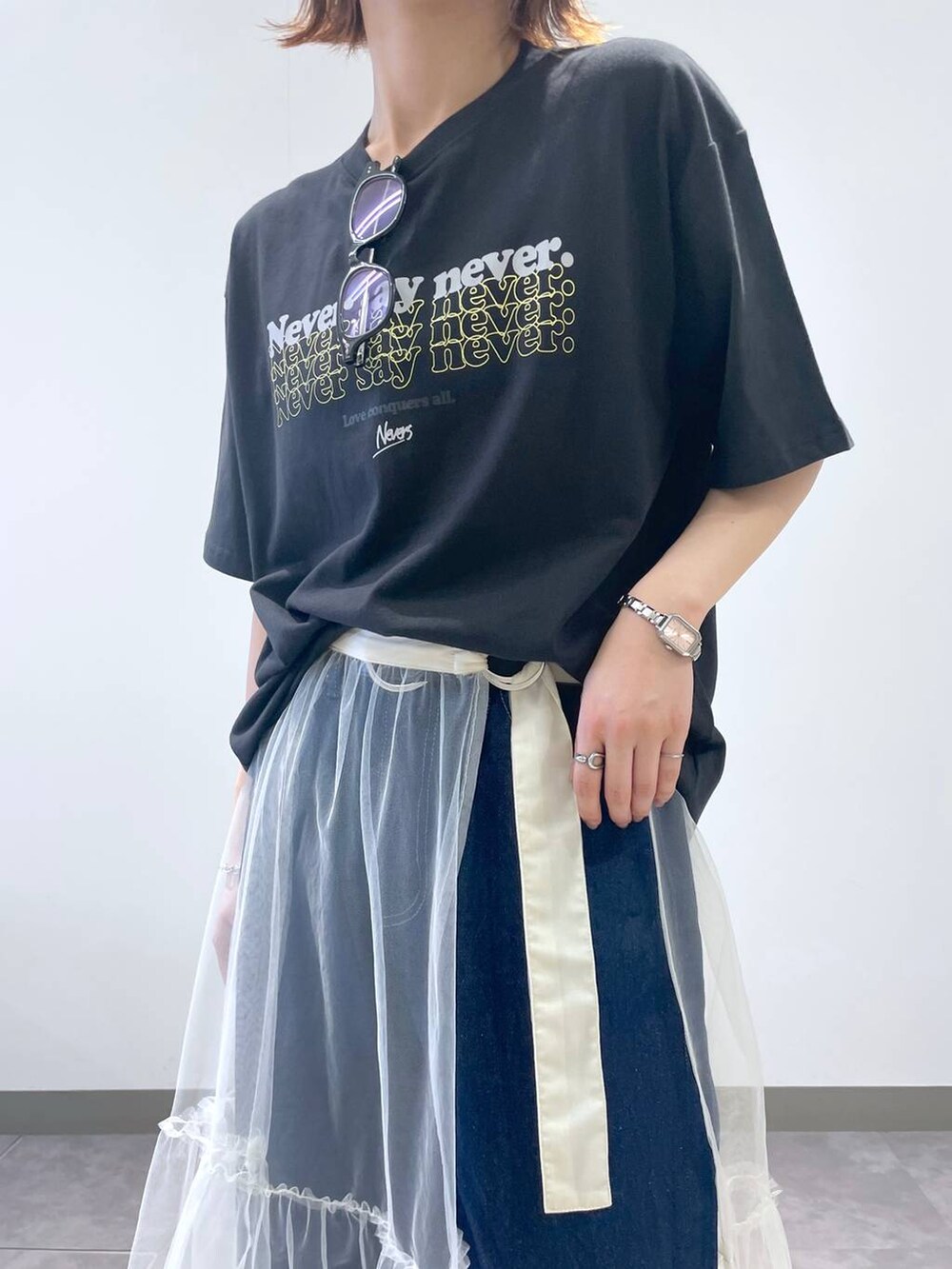 ブラック系のTシャツ/カットソー、ブルー系のデニムパンツ、ブラック系のサンダルを着用したレディースの夏コーディネートの6枚目の写真