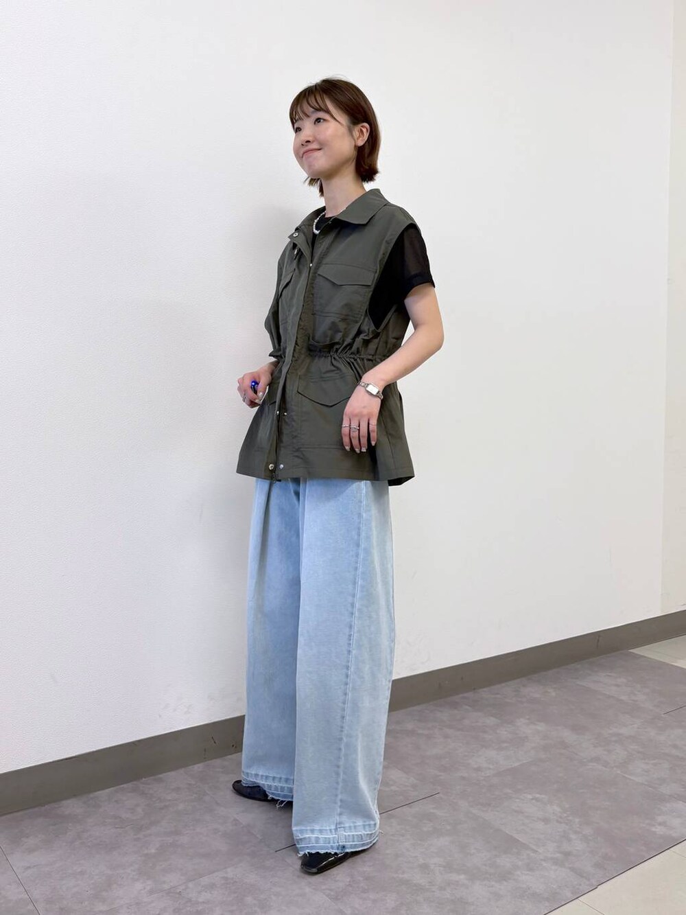 ブラック系のTシャツ/カットソー、ブルー系のデニムパンツ、グリーン系のベストを着用したレディースの夏コーディネートの3枚目の写真