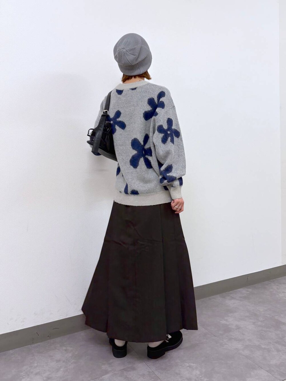 ホワイト系のニット/セーター、ブラウン系のスカート、ブラック系のショルダーバッグを着用したレディースの秋コーディネートの4枚目の写真