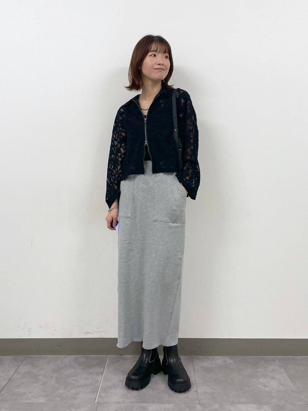 ブラック系のショルダーバッグ、ブラック系のシャツ/ブラウス、ブラック系のブーツを着用したレディースの秋コーディネートの2枚目の写真