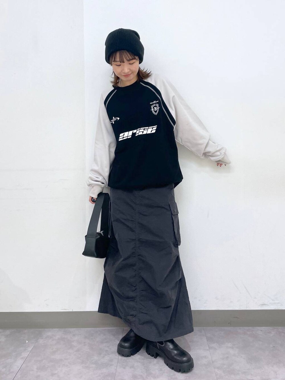 ブラック系のブーツ、ブラック系のショルダーバッグ、ブラック系のスウェットを着用したレディースの冬コーディネートの2枚目の写真