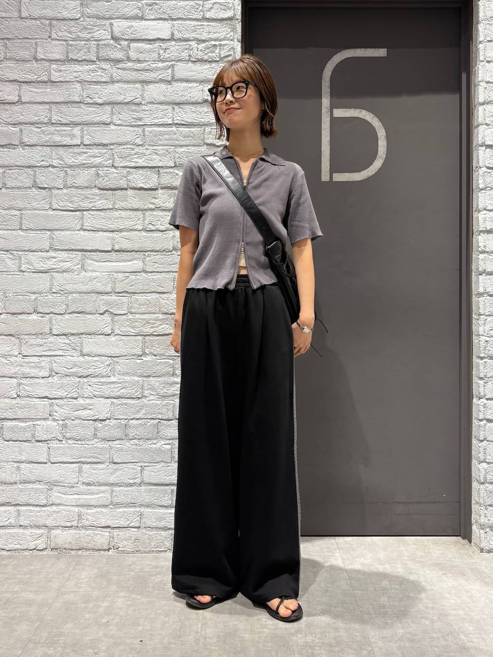 グレー系のニット/セーター、ブラック系のスウェットパンツ、ブラック系のショルダーバッグを着用したレディースの夏コーディネートの5枚目の写真