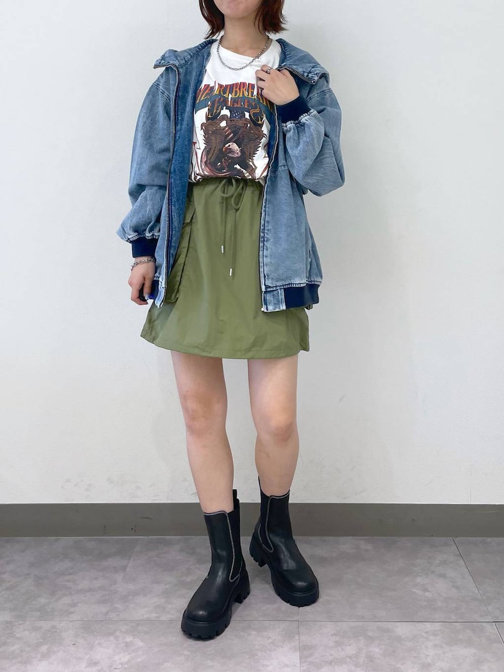 ブルー系のブルゾン、グリーン系のスカート、その他のTシャツ/カットソーを着用したレディースの夏コーディネートの2枚目の写真