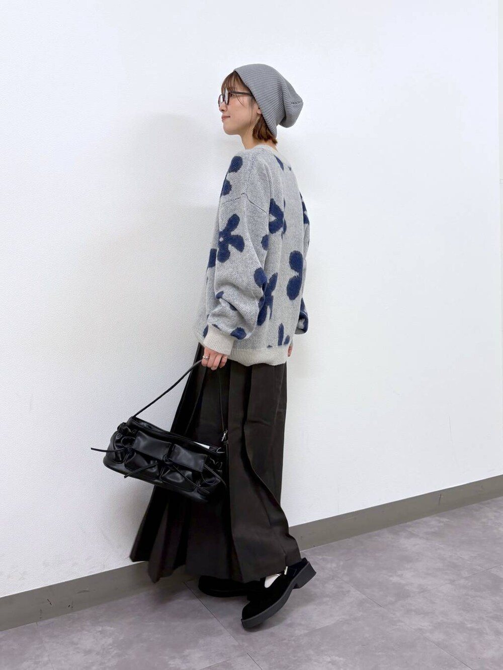 ホワイト系のニット/セーター、ブラウン系のスカート、ブラック系のショルダーバッグを着用したレディースの秋コーディネートの6枚目の写真