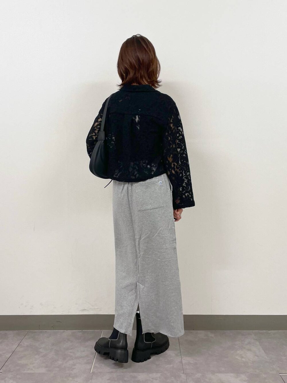 ブラック系のショルダーバッグ、ブラック系のシャツ/ブラウス、ブラック系のブーツを着用したレディースの秋コーディネートの6枚目の写真