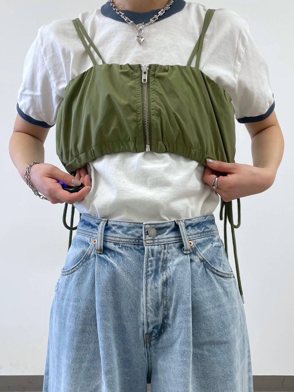 ブラック系のスニーカー、ブルー系のTシャツ/カットソー、ブルー系のデニムパンツを着用したレディースの夏コーディネートの3枚目の写真