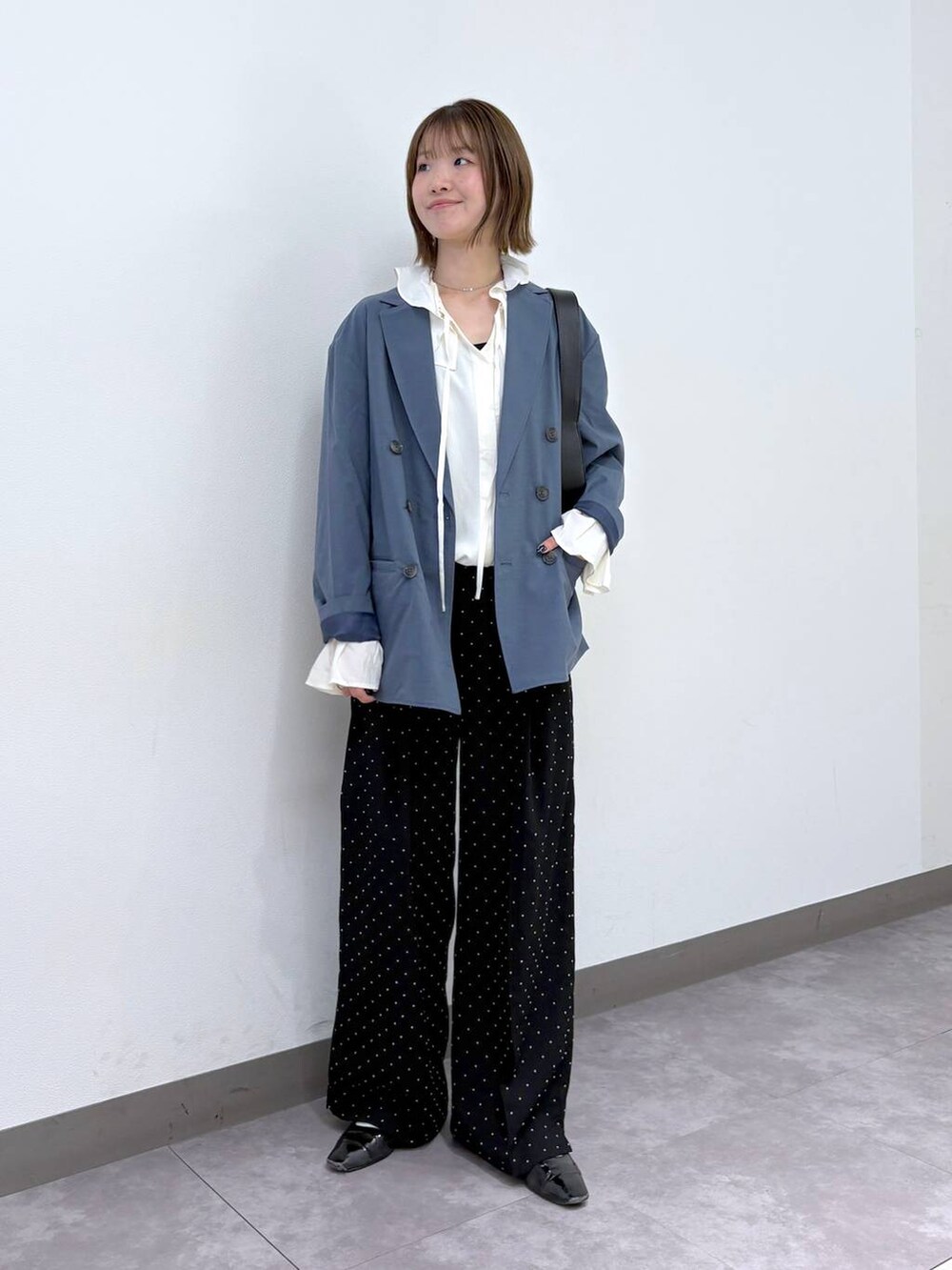 ブルー系のテーラードジャケット、ブラック系のスラックス、ホワイト系のシャツ/ブラウスを着用したレディースの冬コーディネートの5枚目の写真