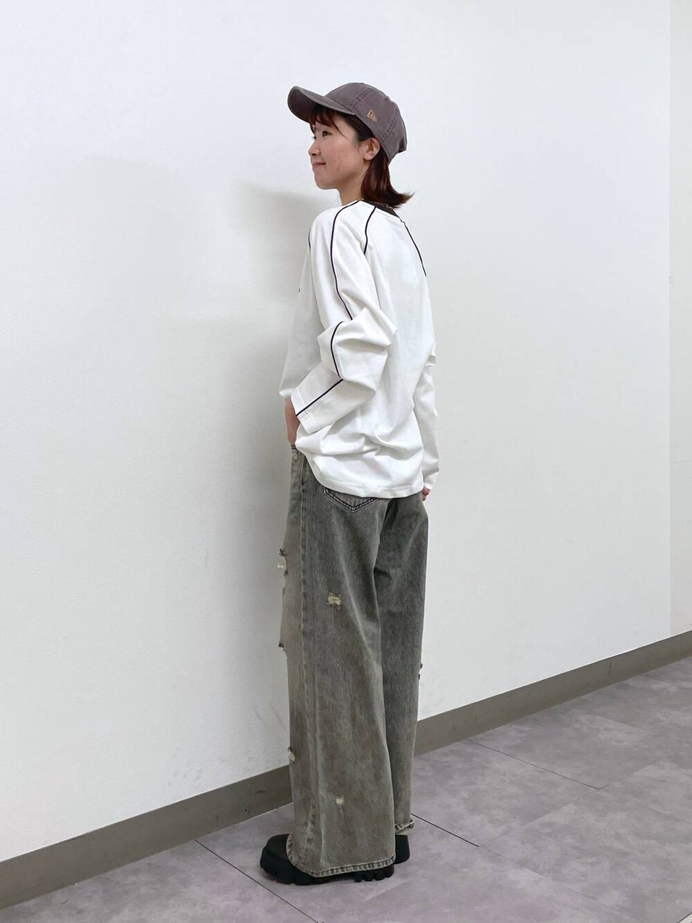 ブラック系のデニムパンツ、ブラック系のブーツ、ホワイト系のTシャツ/カットソーを着用したレディースの秋コーディネートの2枚目の写真