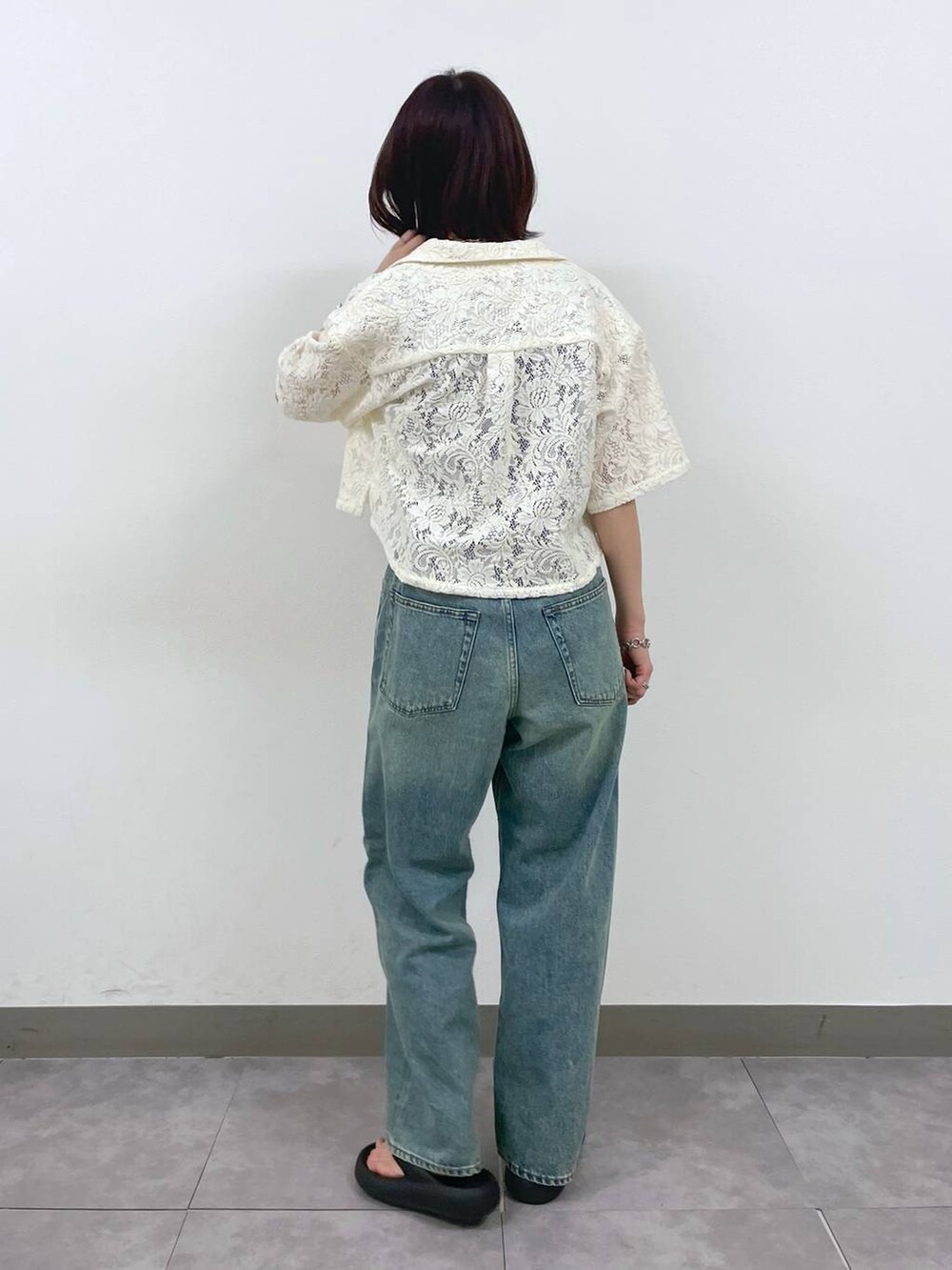 ブルー系のデニムパンツ、ホワイト系のシャツ/ブラウス、シルバー系のブレスレットを着用したレディースの夏コーディネートの3枚目の写真