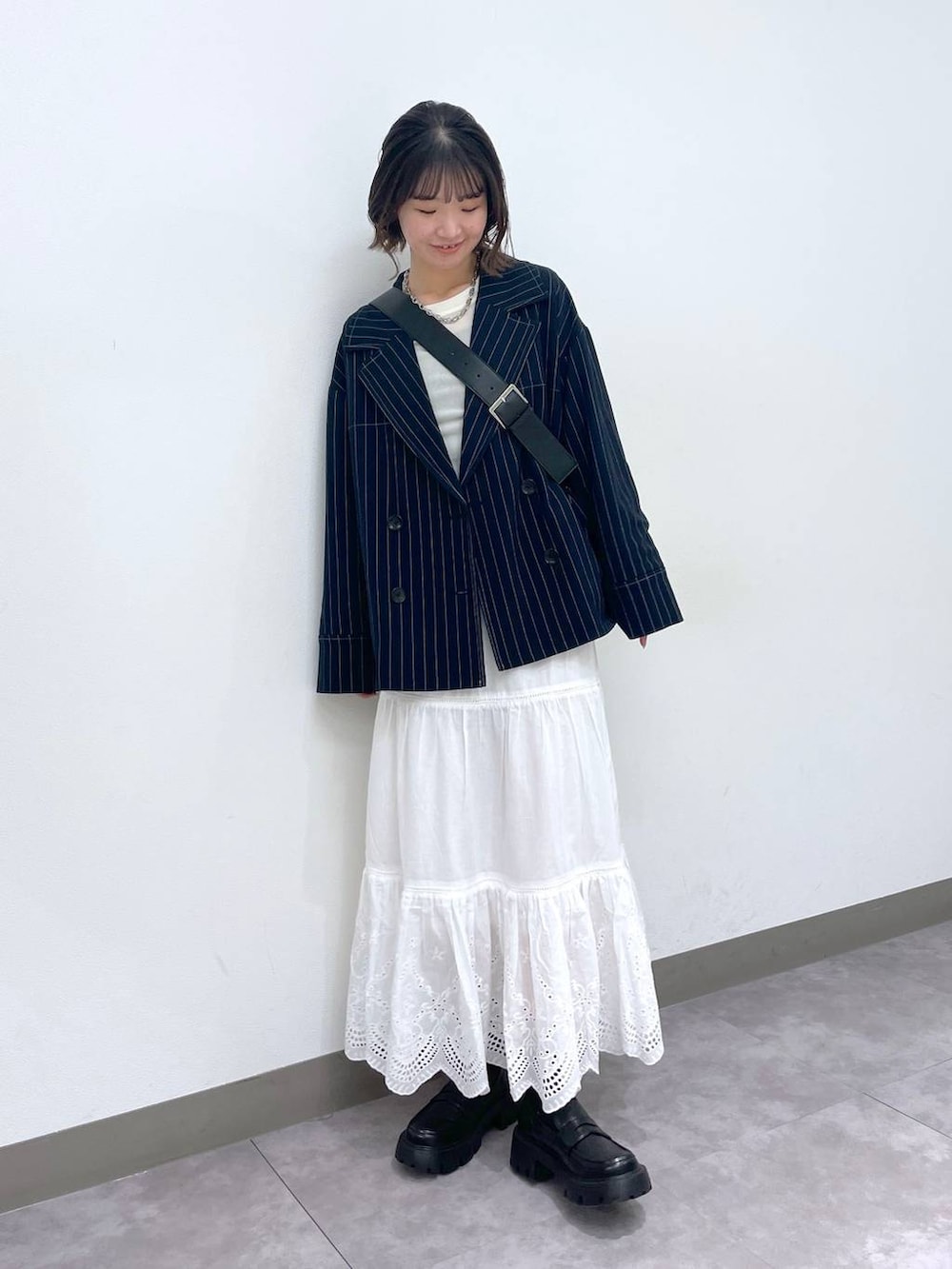 ブラック系のローファー、ブルー系のテーラードジャケット、ホワイト系のTシャツ/カットソーを着用したレディースの冬コーディネートの2枚目の写真