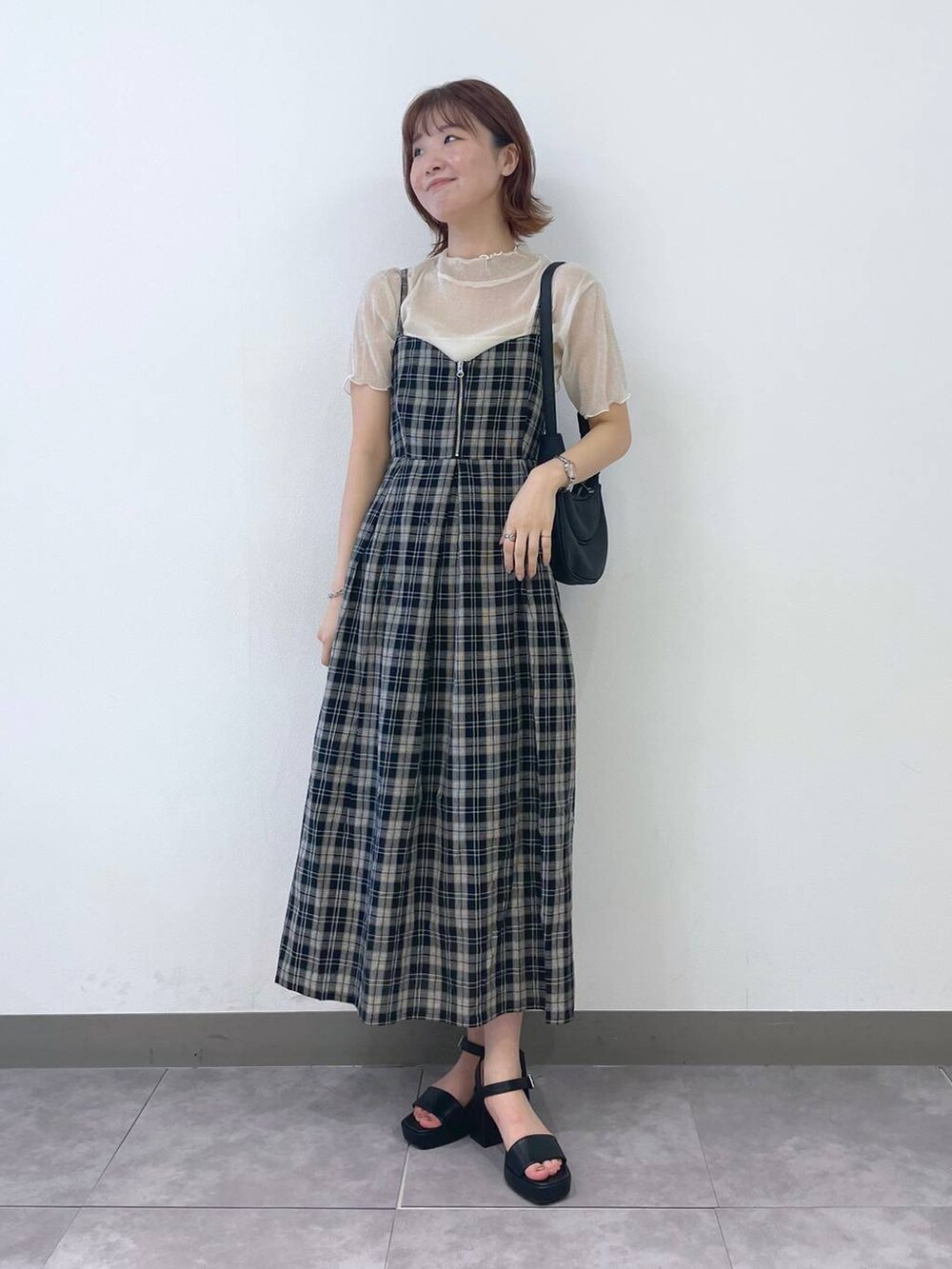 ブラック系のサンダル、ブラック系のワンピース、ホワイト系のキャミソールを着用したレディースの夏コーディネートの5枚目の写真