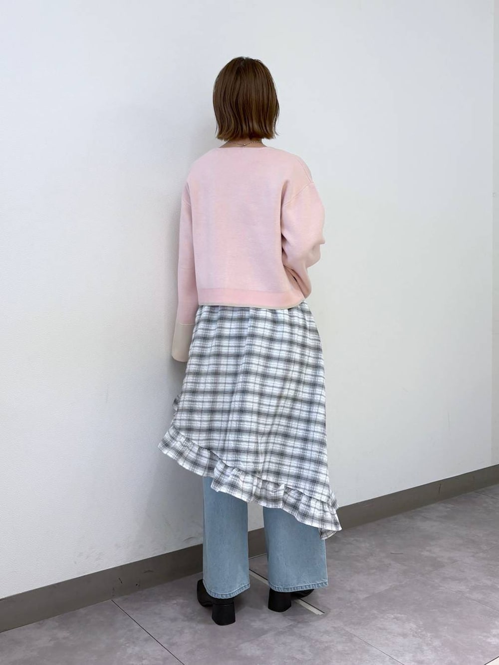 ブルー系のデニムパンツ、ピンク系のカーディガン/ボレロ、ブラック系のブーツを着用したレディースの冬コーディネートの4枚目の写真