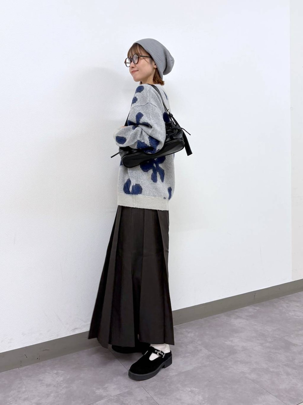ホワイト系のニット/セーター、ブラウン系のスカート、ブラック系のショルダーバッグを着用したレディースの秋コーディネートの3枚目の写真