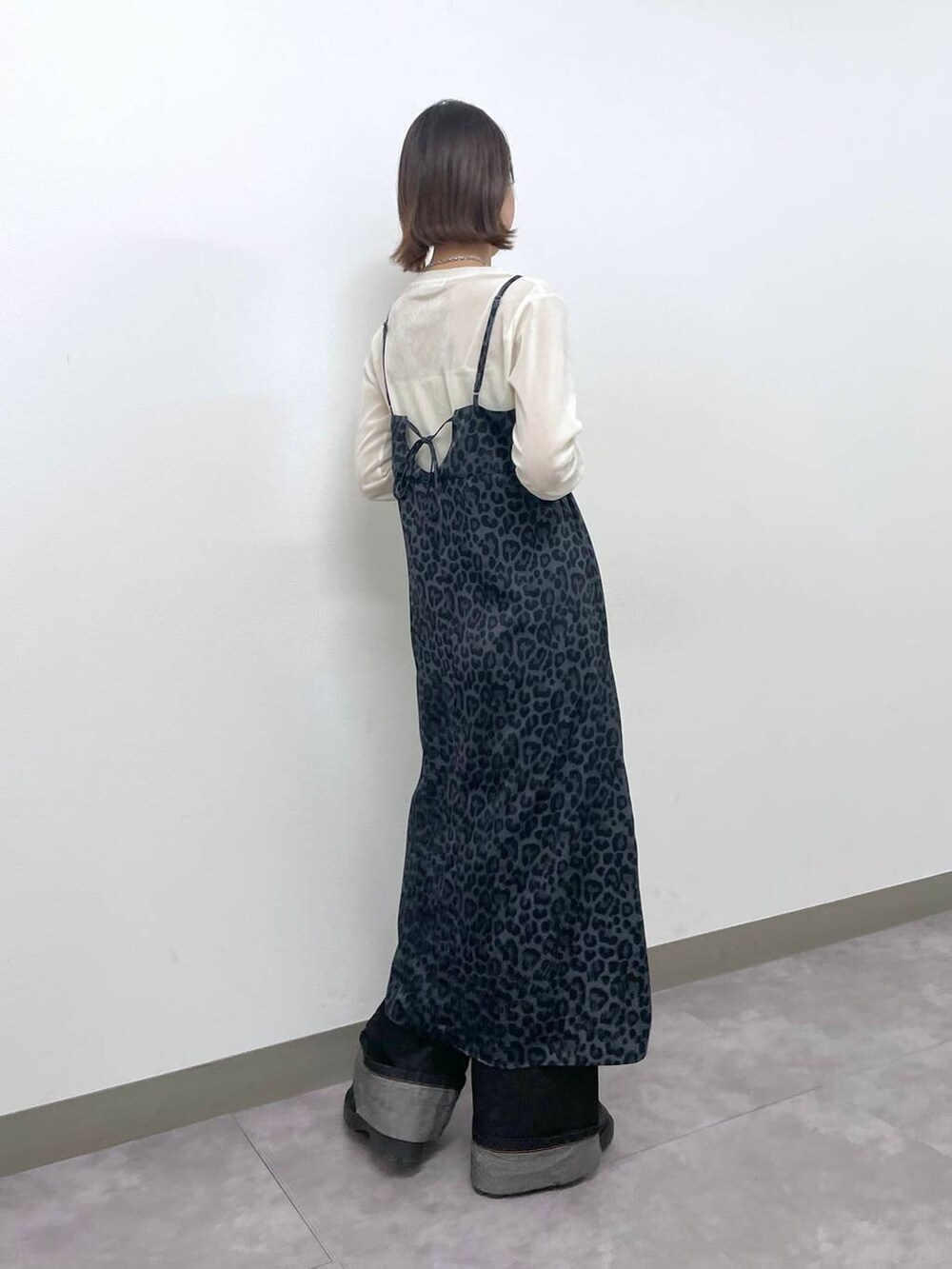 ホワイト系のキャミソール、ホワイト系のTシャツ/カットソー、ブラック系のデニムパンツを着用したレディースの冬コーディネートの3枚目の写真