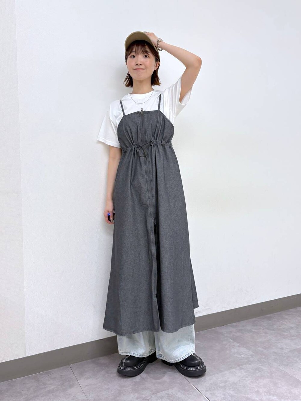 ブラック系のローファー、ブルー系のデニムパンツ、グレー系のワンピースを着用したレディースの春コーディネートの3枚目の写真