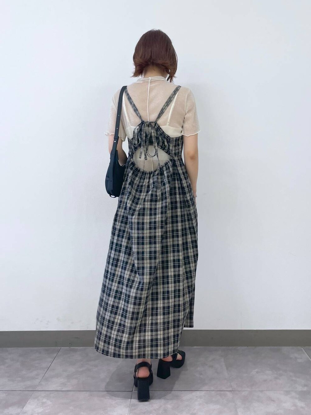 ブラック系のサンダル、ブラック系のワンピース、ホワイト系のキャミソールを着用したレディースの夏コーディネートの3枚目の写真