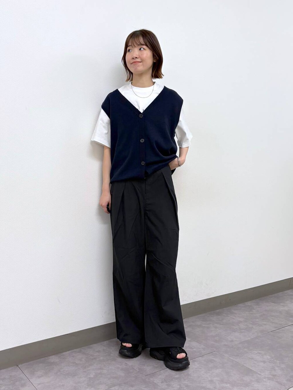 ホワイト系のTシャツ/カットソー、ブラック系のサンダル、ブラック系のカーゴパンツを着用したレディースの春コーディネートの4枚目の写真