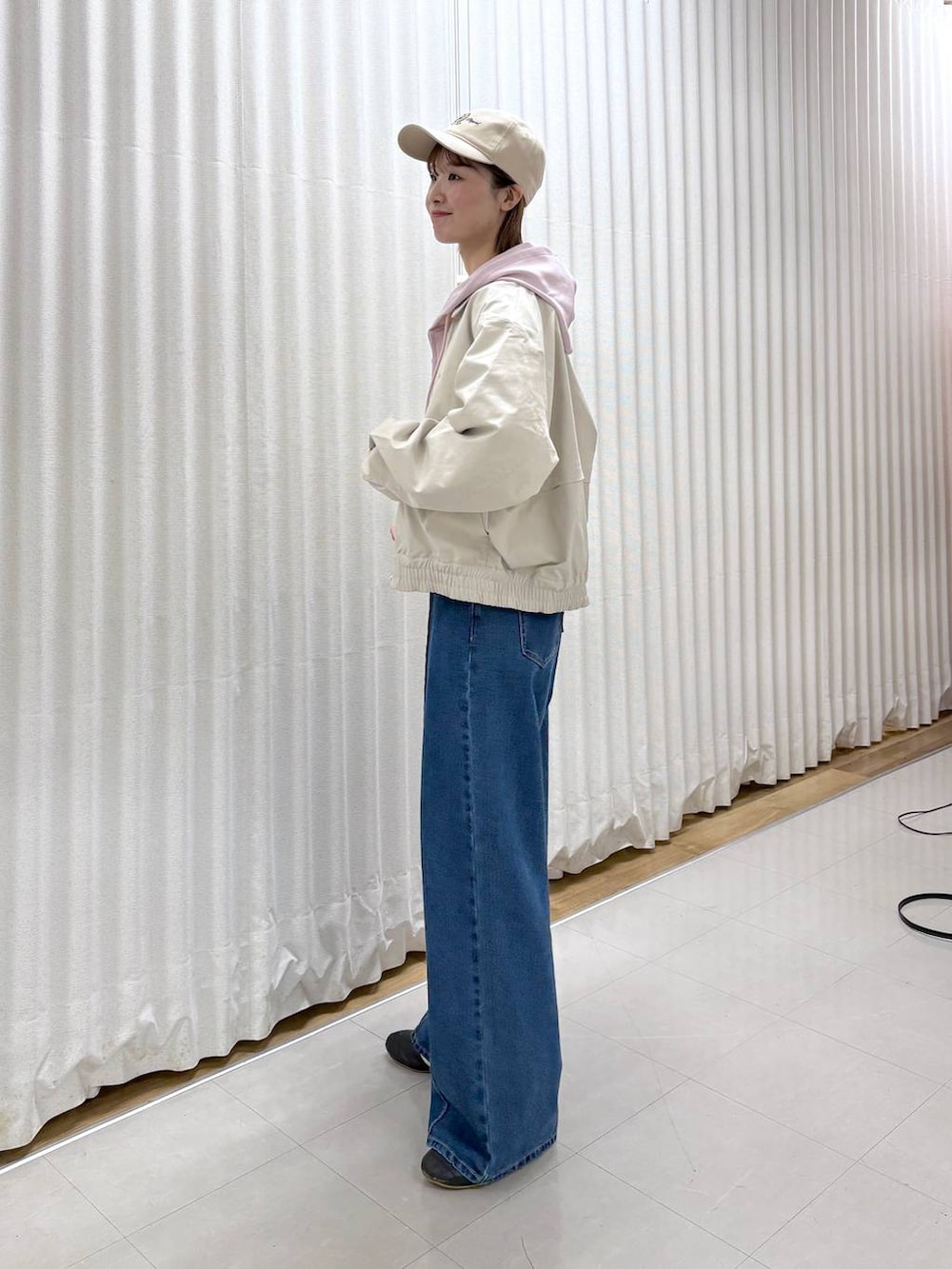 ブラック系のボディバッグ/ウエストポーチ、ブルー系のデニムパンツ、ベージュ系のブルゾンを着用したレディースの春コーディネートの3枚目の写真