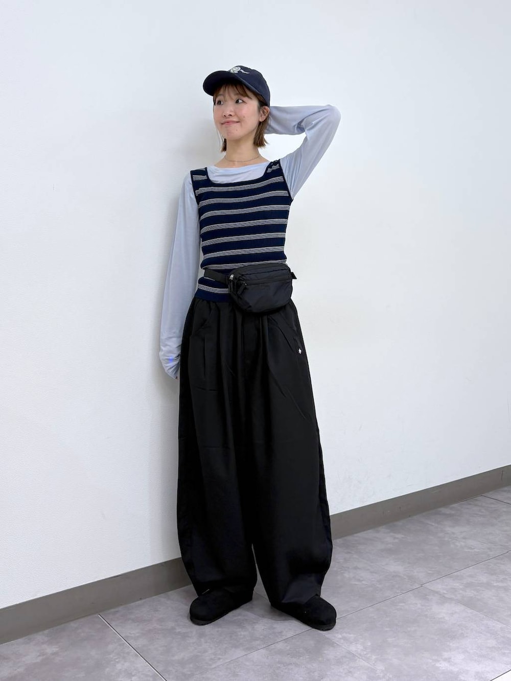 ブラック系のボディバッグ/ウエストポーチ、ブラック系のモカシン/デッキシューズ、ブラック系のスラックスを着用したレディースの春コーディネートの2枚目の写真