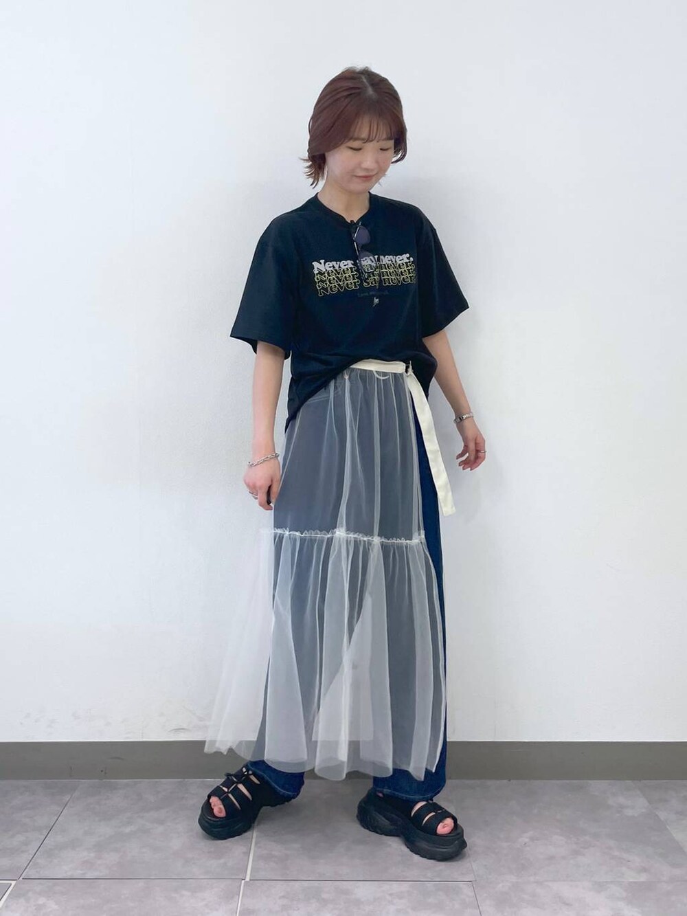 ブラック系のTシャツ/カットソー、ブルー系のデニムパンツ、ブラック系のサンダルを着用したレディースの夏コーディネートの2枚目の写真