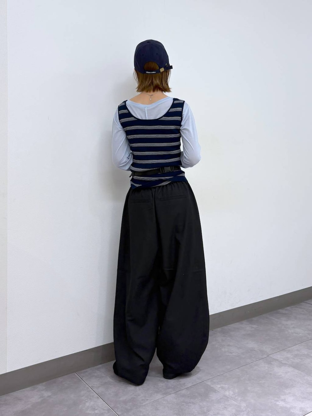 ブラック系のボディバッグ/ウエストポーチ、ブラック系のモカシン/デッキシューズ、ブラック系のスラックスを着用したレディースの春コーディネートの4枚目の写真