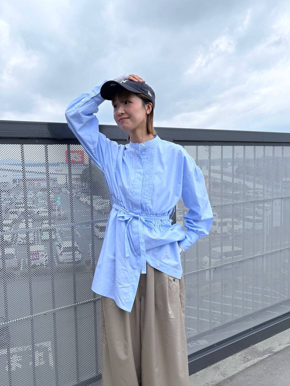 ベージュ系のスラックス、ブルー系のシャツ/ブラウスを着用したレディースの春コーディネートの3枚目の写真