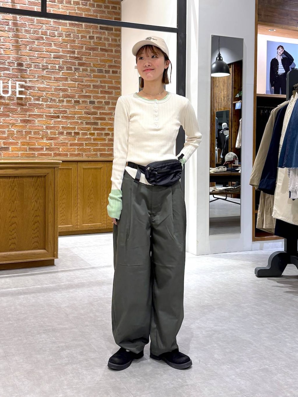 ブラック系のボディバッグ/ウエストポーチ、ホワイト系のニット/セーター、ベージュ系のキャップを着用したレディースの春コーディネートの6枚目の写真
