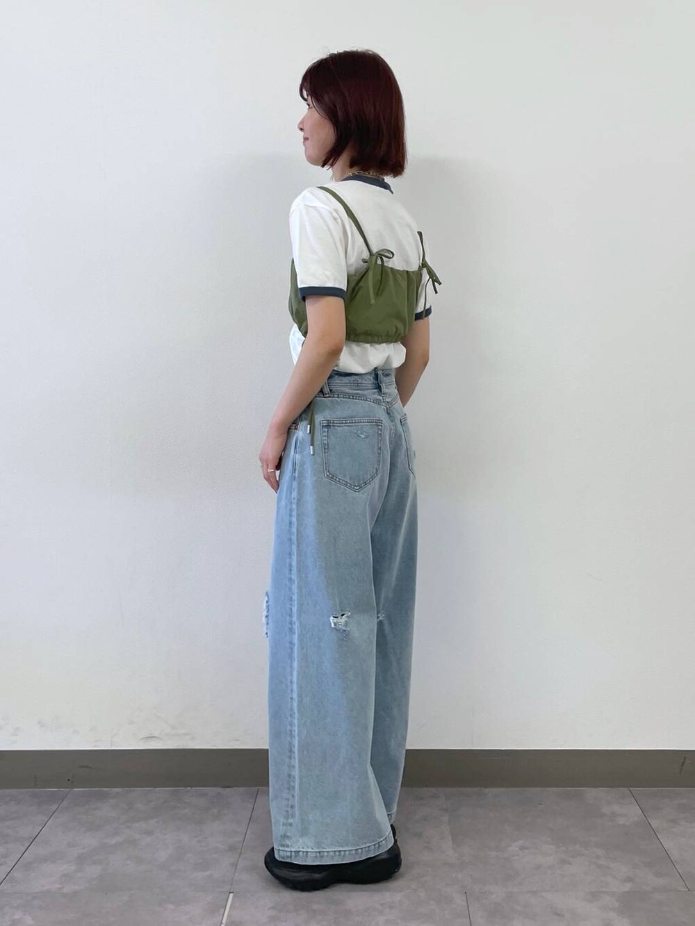 ブラック系のスニーカー、ブルー系のTシャツ/カットソー、ブルー系のデニムパンツを着用したレディースの夏コーディネートの4枚目の写真