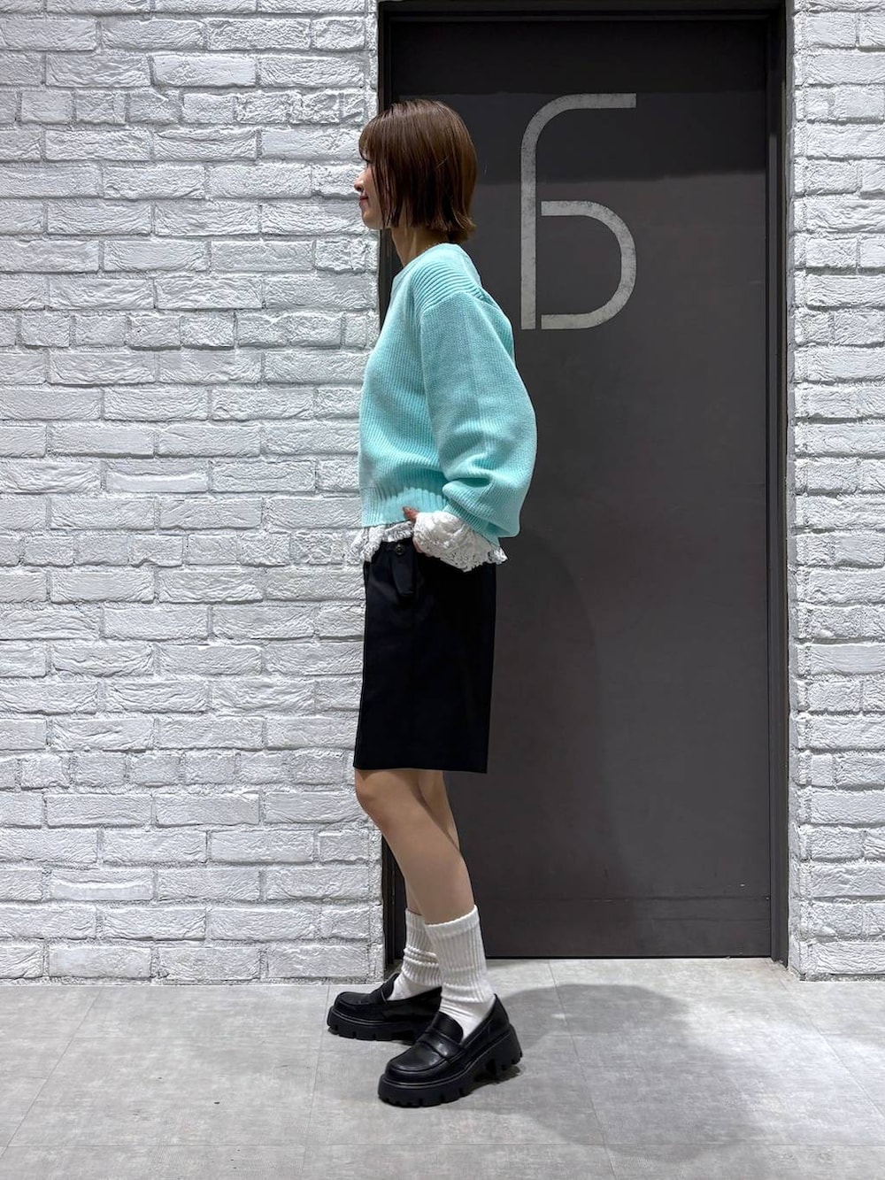 ブラック系のローファー、ブラック系のスラックス、ブルー系のニット/セーターを着用したレディースの冬コーディネートの3枚目の写真