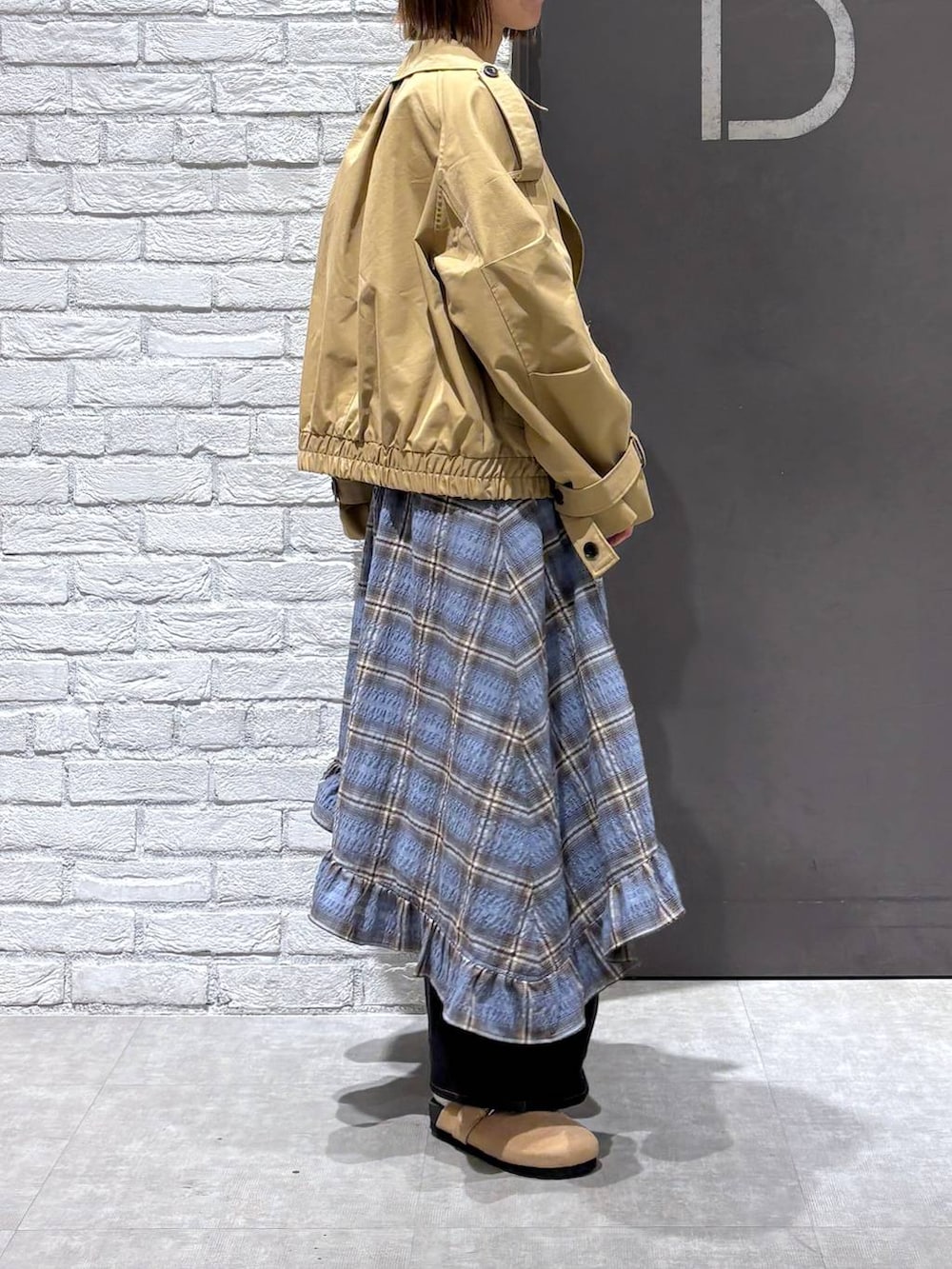 ブラック系のデニムパンツ、ベージュ系のトレンチコート、ブルー系のニット/セーターを着用したレディースの冬コーディネートの4枚目の写真