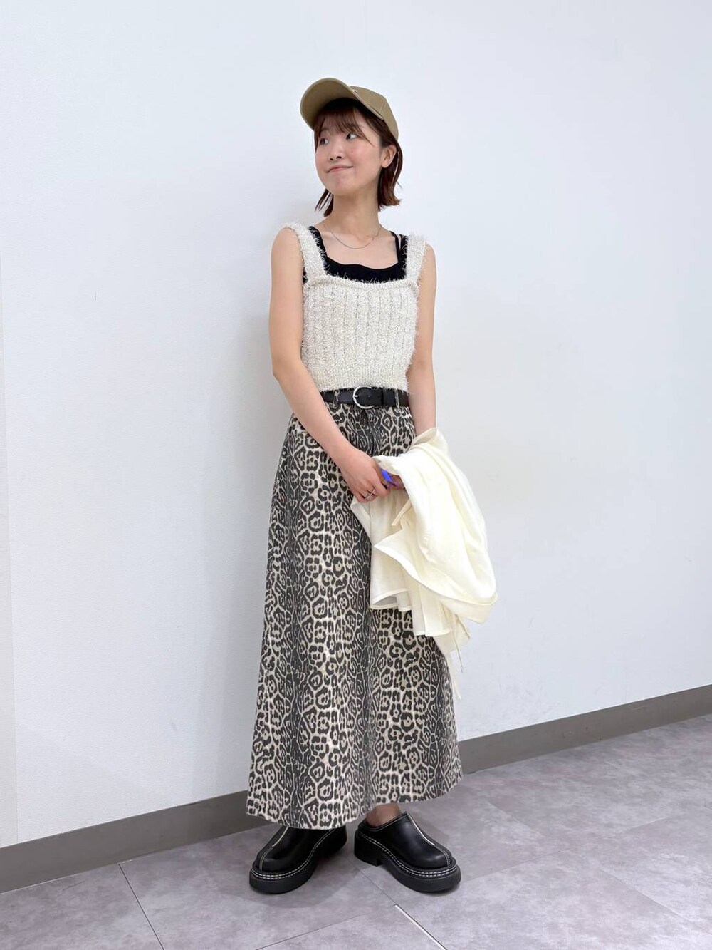 ブラック系のローファー、その他のスカート、ホワイト系のベストを着用したレディースの春コーディネートの2枚目の写真