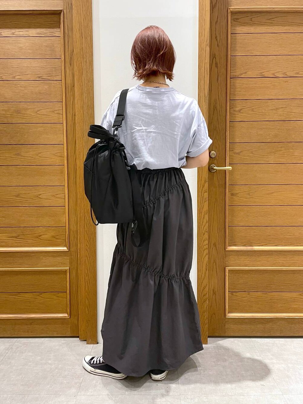 ブラック系のショルダーバッグ、ブルー系のTシャツ/カットソー、グレー系のスカートを着用したレディースの夏コーディネートの3枚目の写真