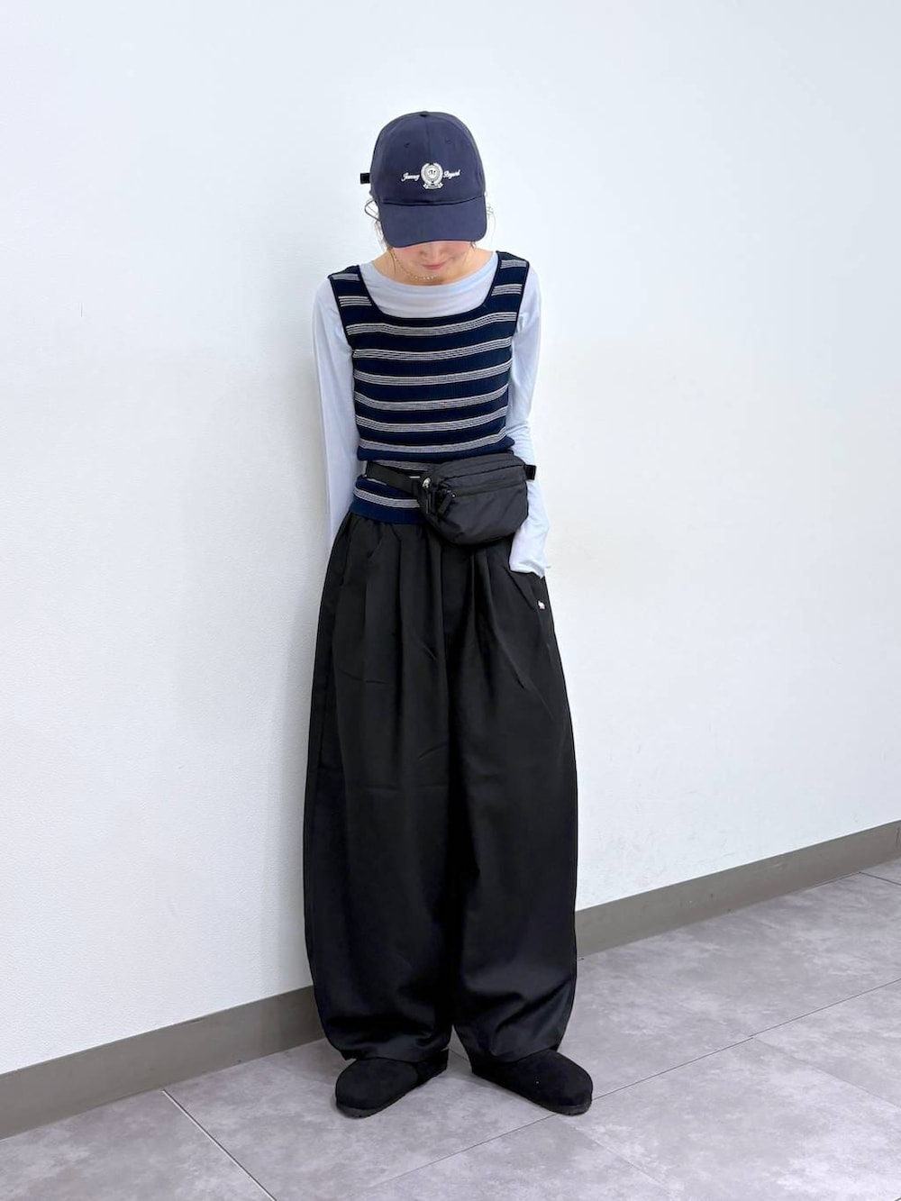 ブラック系のボディバッグ/ウエストポーチ、ブラック系のモカシン/デッキシューズ、ブラック系のスラックスを着用したレディースの春コーディネートの5枚目の写真