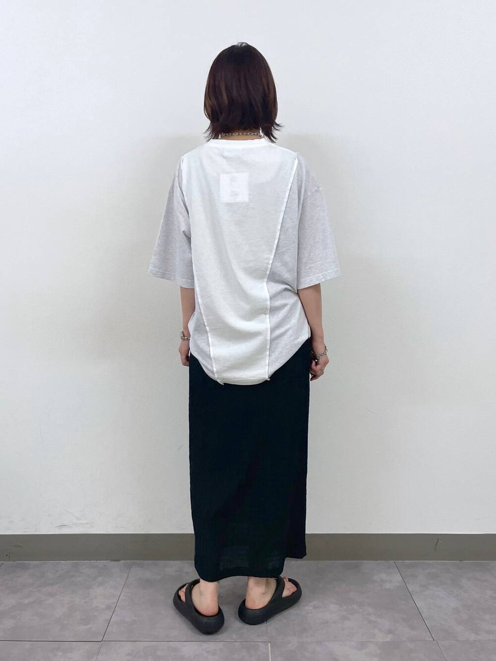 ブラック系のスカート、ホワイト系のTシャツ/カットソー、その他のネックレスを着用したレディースの夏コーディネートの4枚目の写真